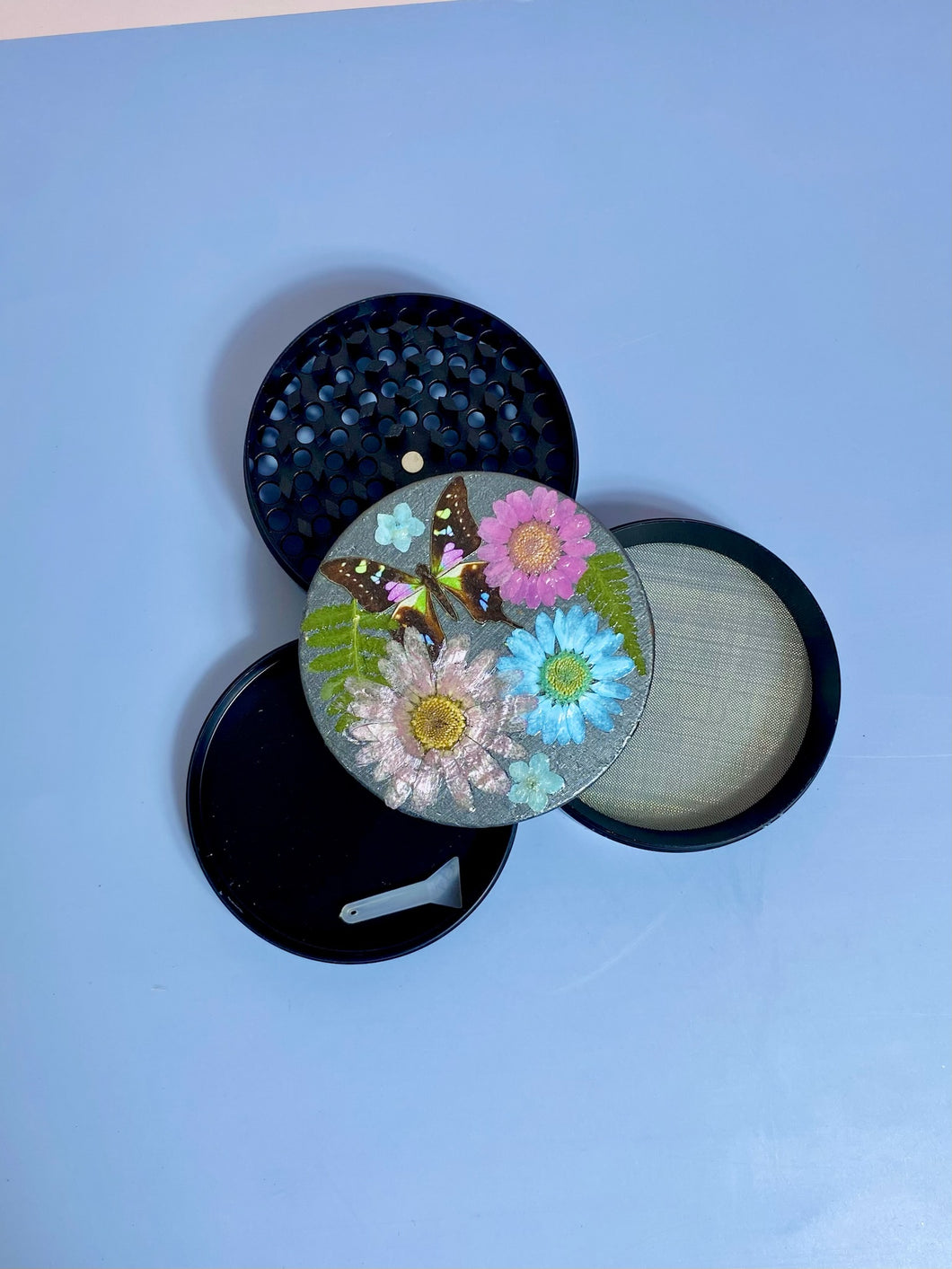 grinder covered in real flowers with butterfly